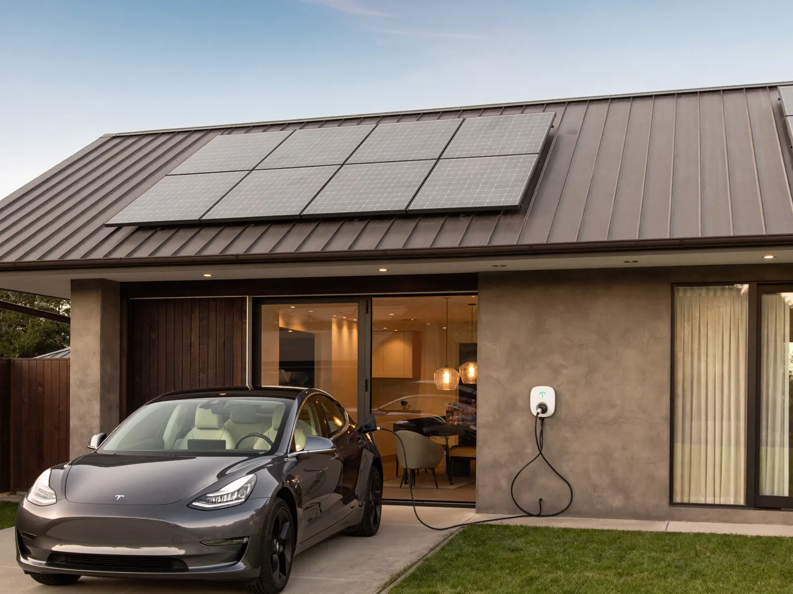 Australian home with solar panels and a Tesla charging in the driveway